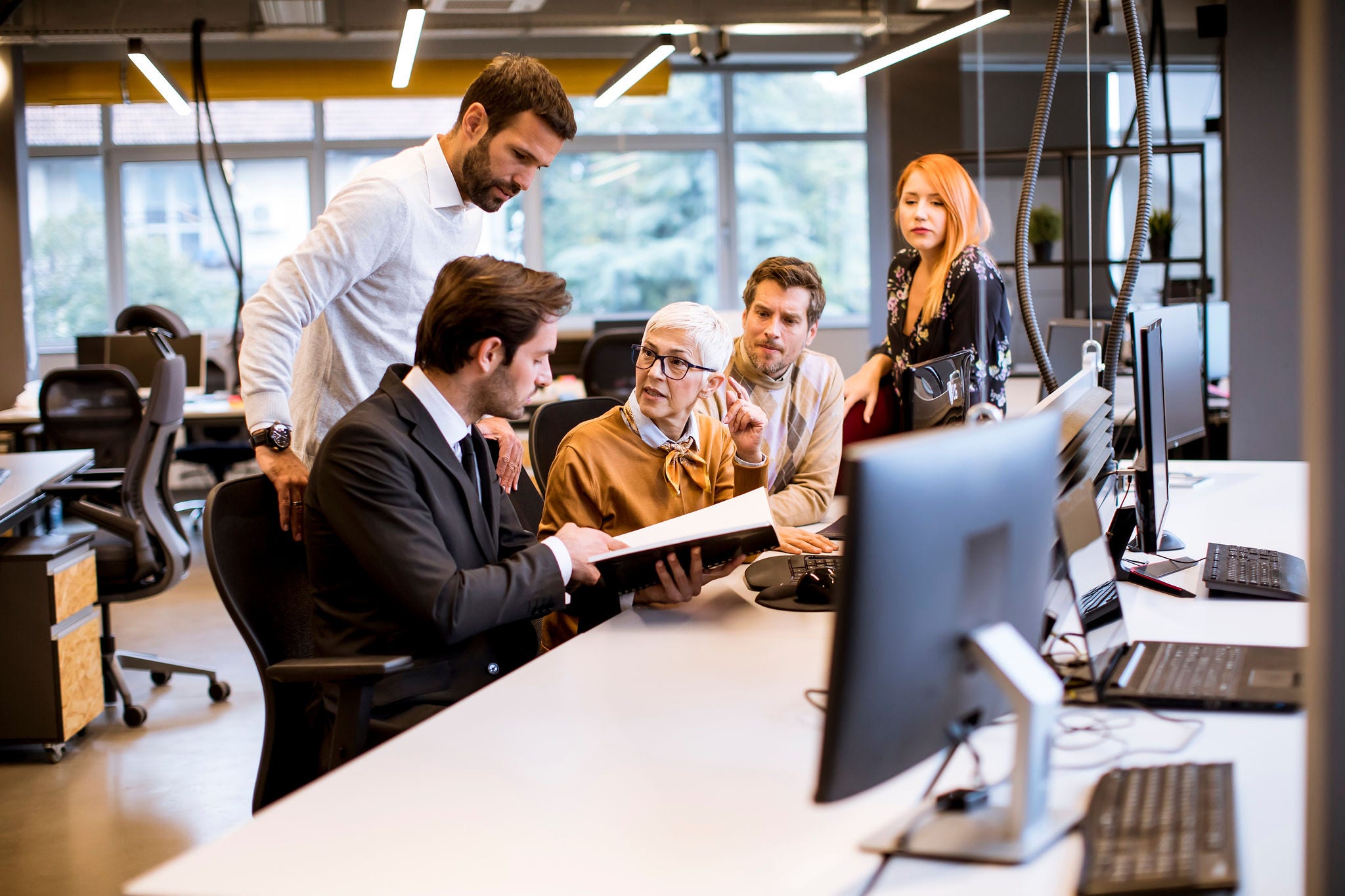 Senior businesswoman working together with young business people in the modern office